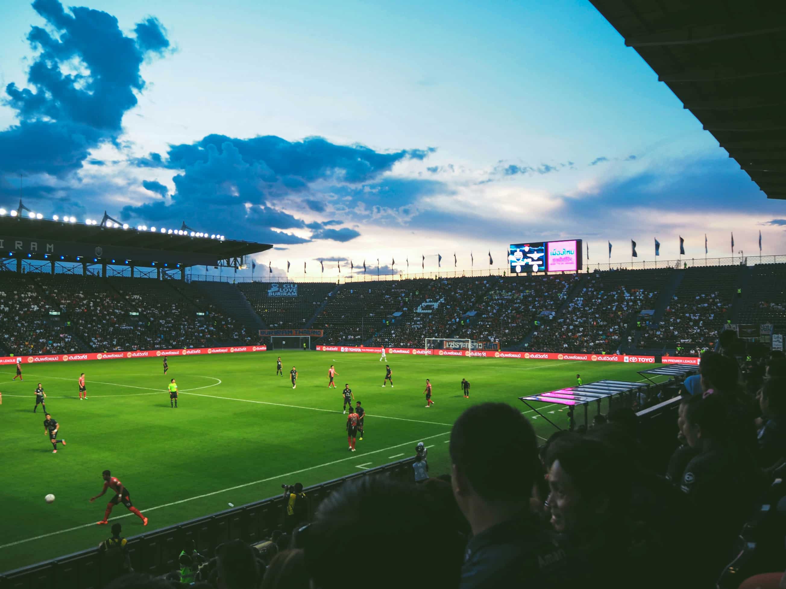 Football pitch with players and lots of fans