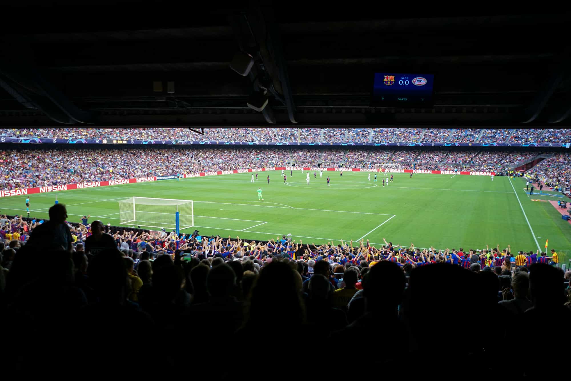 Football pitch with players and lots of fans at a Barcelona FC game.